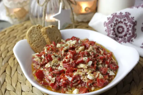 Deliciosa ensalada de pimientos asados con trozos de huevo duro y atún, servida con pan tostado.