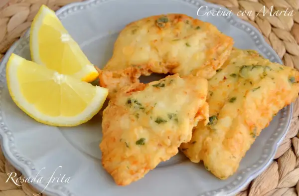 Rosada frita, crujiente y dorada, servida con gajos de limón fresco. Un manjar de mar.